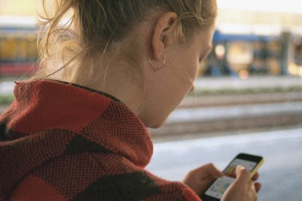 Jente som ser på lydbok på mobil