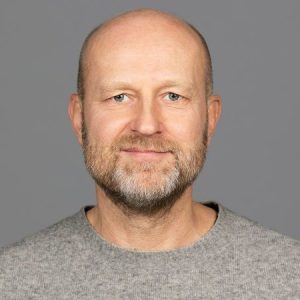 Mann med grå genser og grå bakgrunn