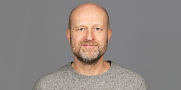 Mann med grå genser og grå bakgrunn