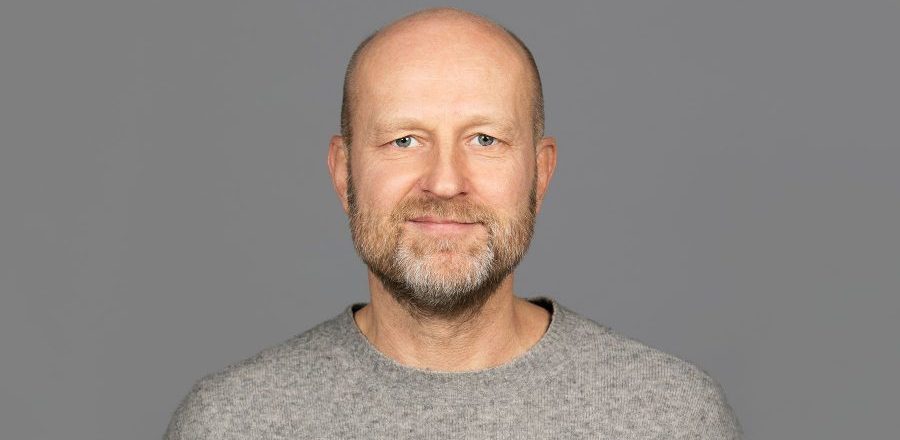 Mann med grå genser og grå bakgrunn